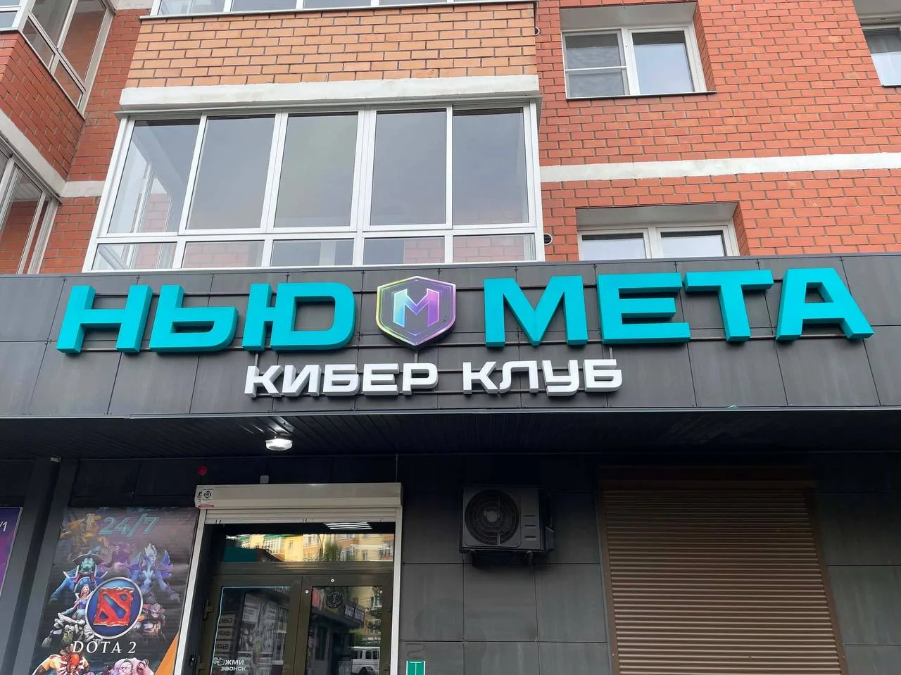 Неоновая вывеска «Нью Мета Кибер клуб» над входом